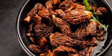 Morels mantarları doğal mantarları sağlıklı yiyecekleri aperatifleri taze lezzetli gurme yemek arka planlarını masadaki rustik yiyecekleri fotokopi alanı keto ve paleo diyeti vejetaryen ve vejetaryen yemekleri.