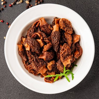 Morels mantarları doğal mantarları sağlıklı yiyecekleri aperatifleri taze lezzetli gurme yemek arka planlarını masadaki rustik yiyecekleri fotokopi alanı keto ve paleo diyeti vejetaryen ve vejetaryen yemekleri.