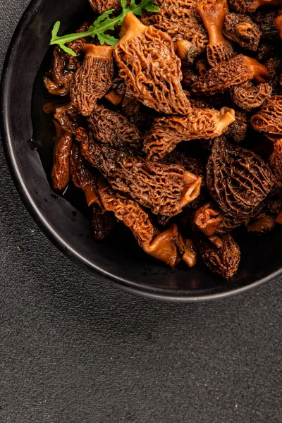 Morels mantarları doğal mantarları sağlıklı yiyecekleri aperatifleri taze lezzetli gurme yemek arka planlarını masadaki rustik yiyecekleri fotokopi alanı keto ve paleo diyeti vejetaryen ve vejetaryen yemekleri.