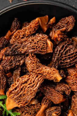 Morels mantarları doğal mantarları sağlıklı yiyecekleri aperatifleri taze lezzetli gurme yemek arka planlarını masadaki rustik yiyecekleri fotokopi alanı keto ve paleo diyeti vejetaryen ve vejetaryen yemekleri.