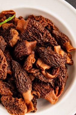 Morels mantarları doğal mantarları sağlıklı yiyecekleri aperatifleri taze lezzetli gurme yemek arka planlarını masadaki rustik yiyecekleri fotokopi alanı keto ve paleo diyeti vejetaryen ve vejetaryen yemekleri.