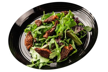 Morel salatası mantarları, yeşil yaprak marul lezzetli aperatif masadaki lezzetli gurme yemek arka planı kırsal yemek fotokopi alanı keto ve paleo diyet vejetaryen ve vejetaryen yemekleri.