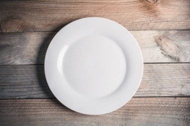 Empty Dinner Plate On A Wooden Board clipart