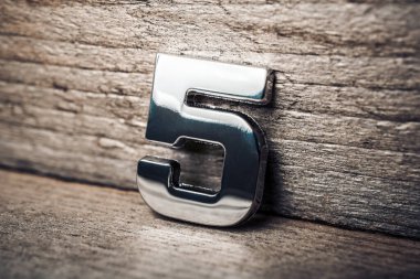 Tahta duvara yaslanan 5 numaralı krom.