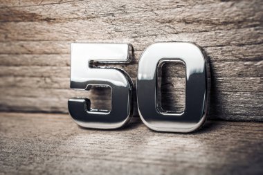 Tahta bir duvara dayanan 50 numaralı krom.