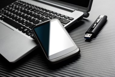 Boş siyah iş Smartphone ile mavi yansıma tüm yukarıda bir karbon tabaka bir Usb depolama birden parlamak götürmek yanında dizüstü bilgisayar klavyesindeki yaslanmış