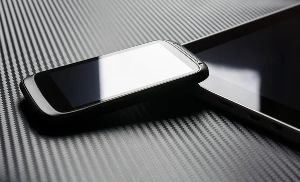 Blank Business Smartphone With Reflection Leaning On Tablet With Carbon Background — Stockfoto