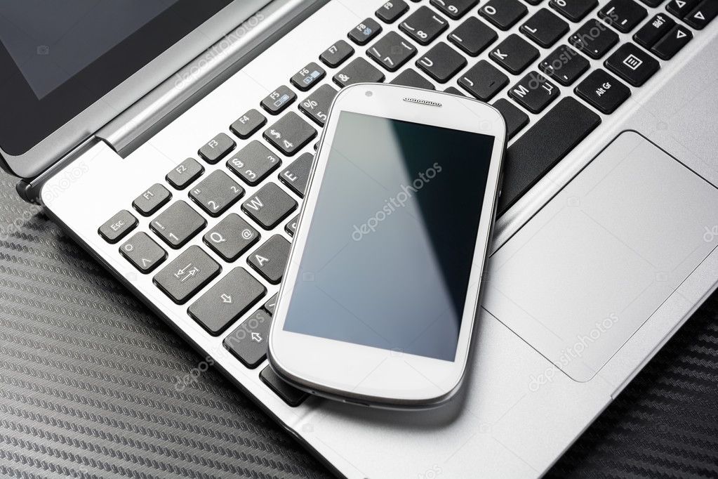 Blank Business Phone With Reflection Lying On A Notebook Keyboard With, All Above A Carbon Layer