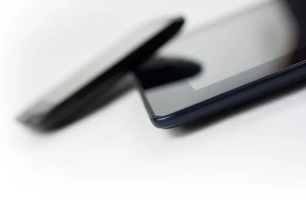 Czarny Smartphone oparty na tabletki — Zdjęcie stockowe