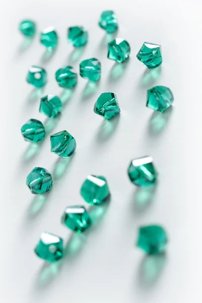 Kolekce mnoha zelených dvojité kužele krystaly v bílé krabici — Stock fotografie