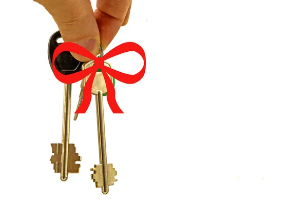 Beyaz zemin üzerine kırmızı yay ile dairenin anahtarları — Stok fotoğraf