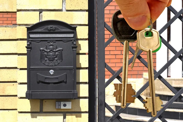 The keys to the apartment in hand on the background of houses