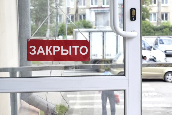 Een bord met rode letters op de voordeur — Stockfoto