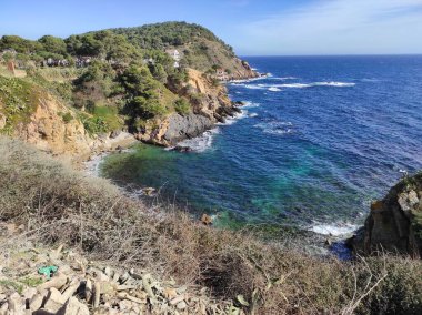 Cala aşağıdaki saksıları, Palamlar 'da, altın çakıl taşlı bir plaj, ve soldaki Cap Gros. Kayalık kayalıklar. Güzel ve güneşli bir gün Manzarayı aydınlatır.