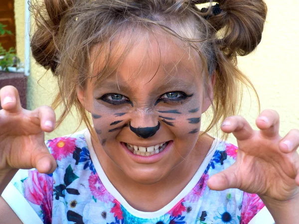Flicka målade som en kattunge, morrande visar tänderna. — Stockfoto