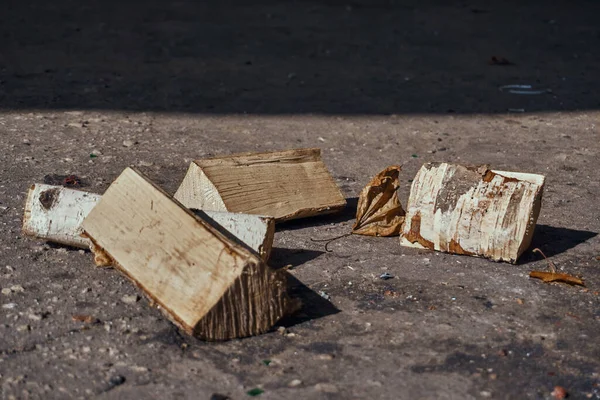 Montón de troncos talados con corteza, se encuentran en el asfalto. Una pila de abedul para una fogata. Descanse en la naturaleza. Enfoque selectivo. — Foto de Stock