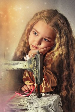 Retro giysili ve kıvırcık saçlı bebek hüzünle oturur ve yana bakar. Çocuğun önünde bir retro dikiş makinesi var. Dikiş işi kavramı, kendi ellerinle. Seçici odaklanma. retro