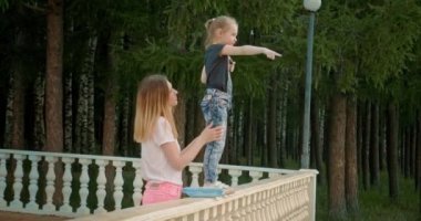 Anne ve kızı gözlem güvertesinde durup göl ve ufuk arasındaki mesafeye bakıyorlar. Açık hava yürüyüşleri için güneşli bir yaz..