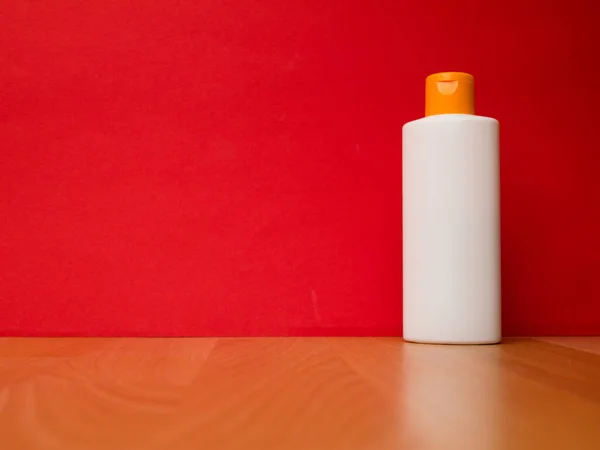 Λευκό μπουκάλι σωλήνα σαμπουάν, conditioner, στοματικό διάλυμα, σε κόκκινο φόντο. — Φωτογραφία Αρχείου