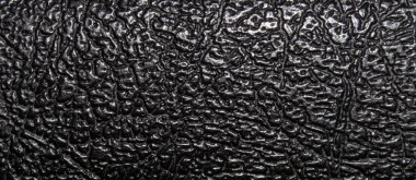 Black plastic veined texture and pattern. Closeup