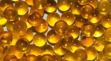 Beyaz arka plan üzerinde yuvarlak şeffaf altın topları doku. Karaca balık, balık yağı. Portre