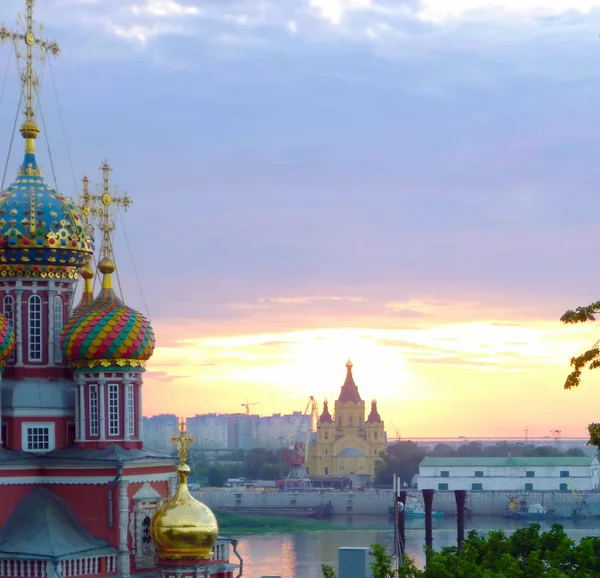 Zwei Kathedralen auf dem Hintergrund des scharlachroten Sonnenuntergangs und des Flusses. nischni nowgorod, russland — Stockfoto