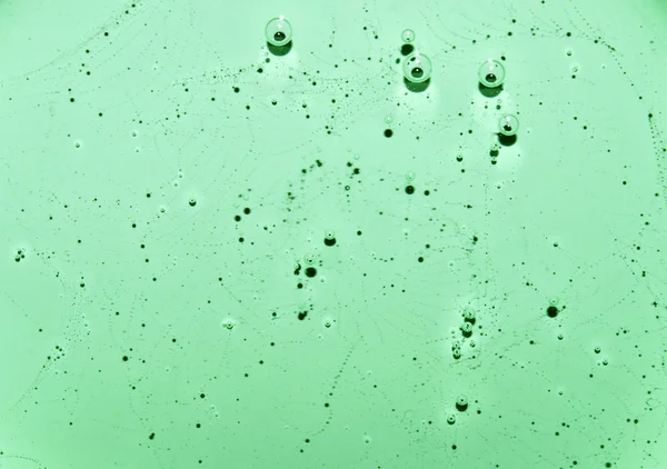 Texture fluida verde chiaro con motivi e bolle. Acqua verde chiaro con bolle. Primo piano — Foto Stock