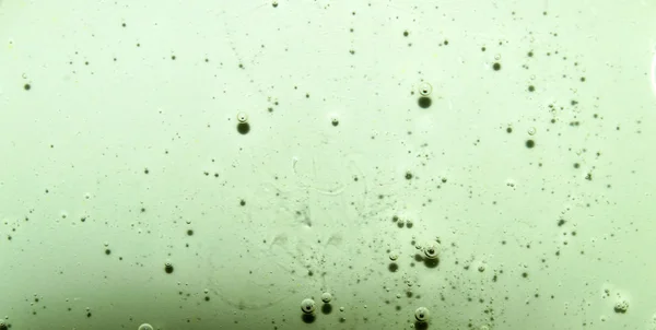 Light green transparent texture of the liquid with bubbles. Light green water with bubbles. Closeup — Stock Photo, Image