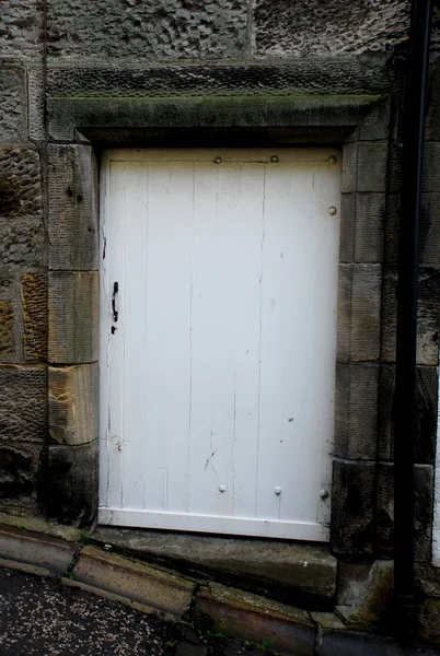 Uma porta da frente de madeira branca em uma casa de pedra cinza na Escócia — Fotografia de Stock