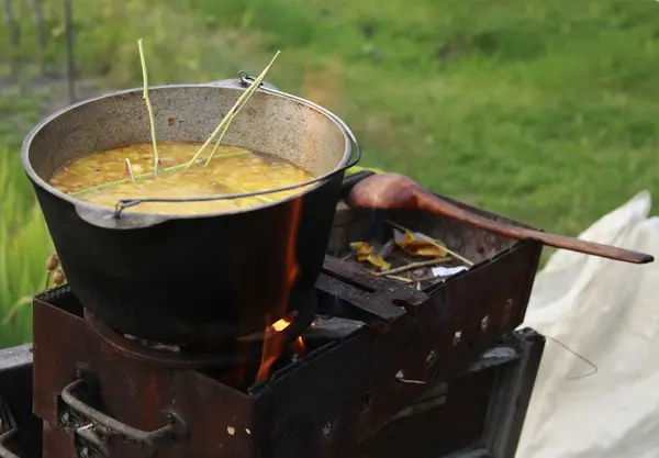 Jantar cozinhando em uma fogueira aberta no jardim — Fotografia de Stock