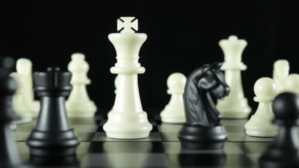 Černý pěšák krájí bílou královnu na šachovnici — Stock video