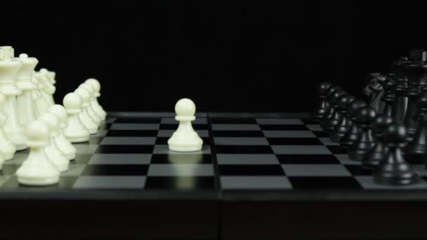 Eine Schachpartie. Die Hand eines Mannes bewegt einen Bauern auf dem schwarzen Schachbrett. — Stockvideo