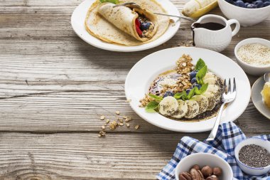 Sağlıklı kahvaltı eğilim. İnce yulaf krep muz, yaban mersini, goji Karpuzu, susam ve chia tohumu ile