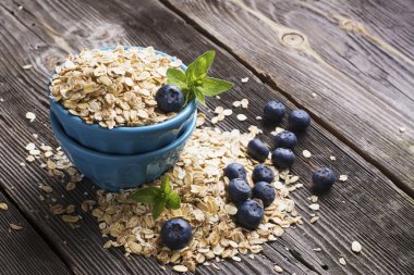 Mavi seramik kase tahıl gevreği ve koyu ahşap arka plan üzerinde taze çilek blueberry Bahçe dolu