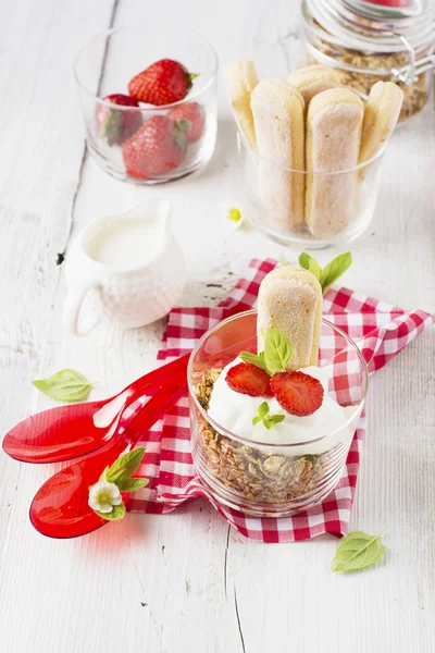 Strawberry yogurt with muesli on a old wooden background — Stock Photo, Image