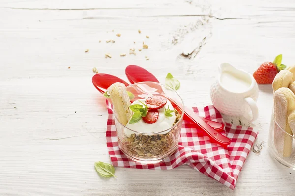 Iogurte de morango com muesli em um velho fundo de madeira — Fotografia de Stock