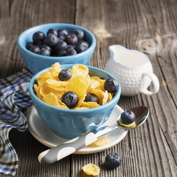 健康的な朝食。コーンフレーク新鮮なブルーベリーと分配されたセラミック ブルー ボウルします。 — ストック写真