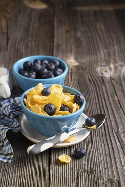 健康的な朝食。コーンフレーク新鮮なブルーベリーと分配されたセラミック ブルー ボウルします。 — ストック写真