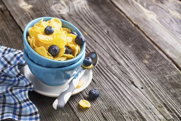 Desayuno saludable. Cuencos de cerámica porcionados azules con copos de maíz arándanos frescos —  Fotos de Stock