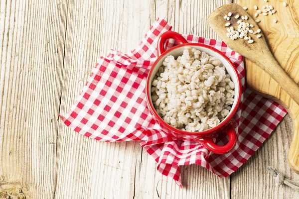 La pentola in ceramica rossa con pois bianchi completa friabile porridge d'orzo — Foto Stock