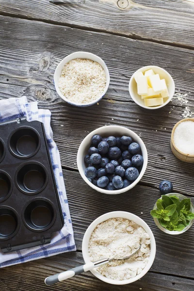 Gâteaux maison sains. Ingrédients pour muffins aux myrtilles sur fond bois foncé — Photo