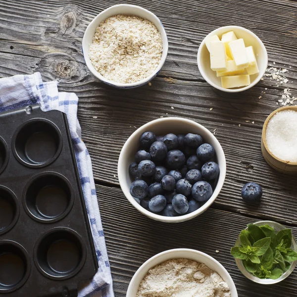 Bolos caseiros saudáveis. Ingredientes para muffins de mirtilo em um fundo de madeira escura — Fotografia de Stock