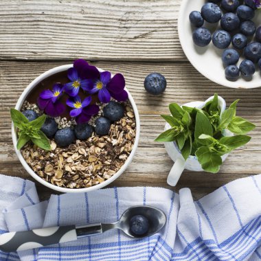 Bir tepesi granola, yaban mersini, beyaz susam ile Çikolatalı muz Smoothies kase