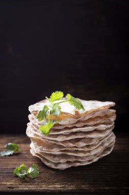 Vegetarinskogo ve sağlıklı beslenme için nohut unu ile yararlı ev kek Kule ince gevrek somun. Koyu ahşap arka plan üzerinde kişniş nohut kuru sprigs.