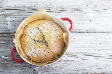 Bisküvi kırıntıları ile Hassas kokulu ev yapımı kremalı pasta ahşap arka plan üzerinde kireç ve lavanta çiçekleri bir dilim dekore edilmiştir. Fikir dekorasyon pişirme. seçici Odaklama