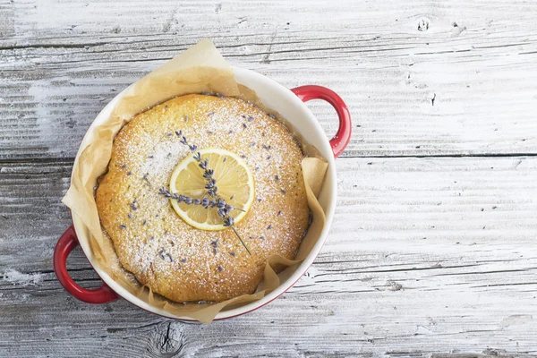 Bisküvi kırıntıları ile Hassas kokulu ev yapımı kremalı pasta ahşap arka plan üzerinde kireç ve lavanta çiçekleri bir dilim dekore edilmiştir. Fikir dekorasyon pişirme. seçici Odaklama