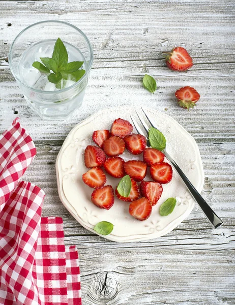 Gesunder leichter Frühstückssnack. Erdbeerscheiben mit Zucker, Basilikum, Minze zum Dessert auf Holzgrund. — Stockfoto