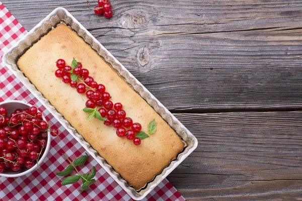 Eenvoudige zelfgemaakte cake van griesmeel in een ovenschaal met bessen rode bessen. De bovenste weergave. — Stockfoto