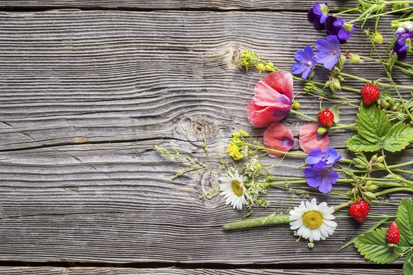 Ahşap arka plan üzerinde çeşitli yaz kır çiçekleri — Stok fotoğraf