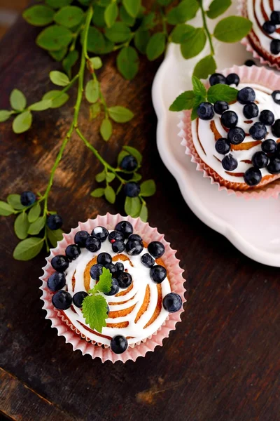 homemade cupcakes with icing and blueberries